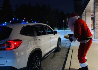 Santa hands out gifts to West Oakville Preschool Centre family in their car